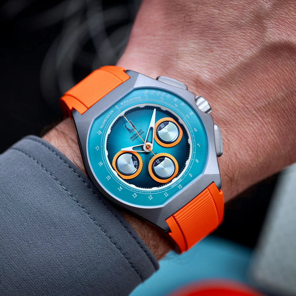 Isotope Moonshot Chronograph with teal dial and orange strap, worn on the wrist